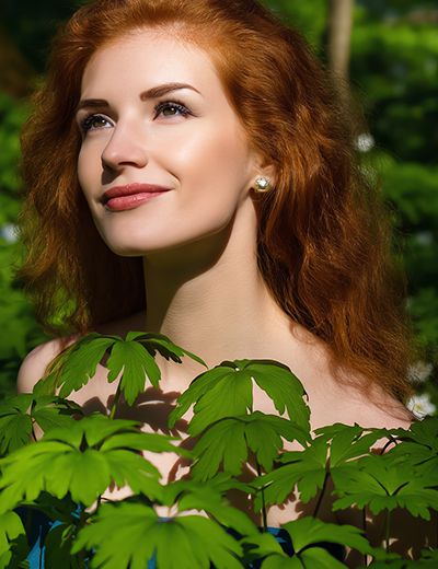 Woman with smooth, hydrated skin framed by green foliage, representing urea’s moisture-binding and skin-softening benefits in advanced skincare formulations.